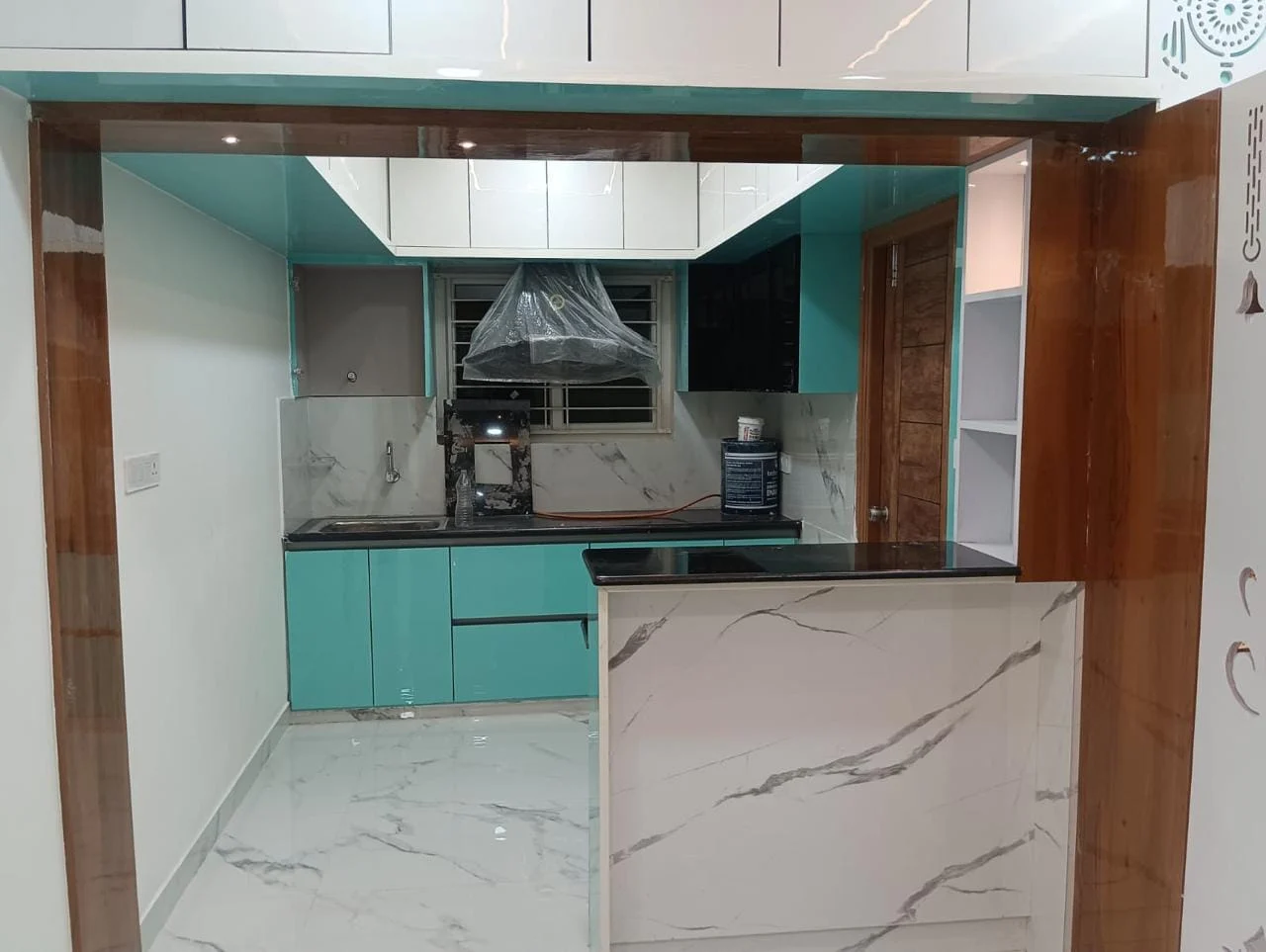 Client modular kitchen with turquoise cabinetry and marble breakfast counter